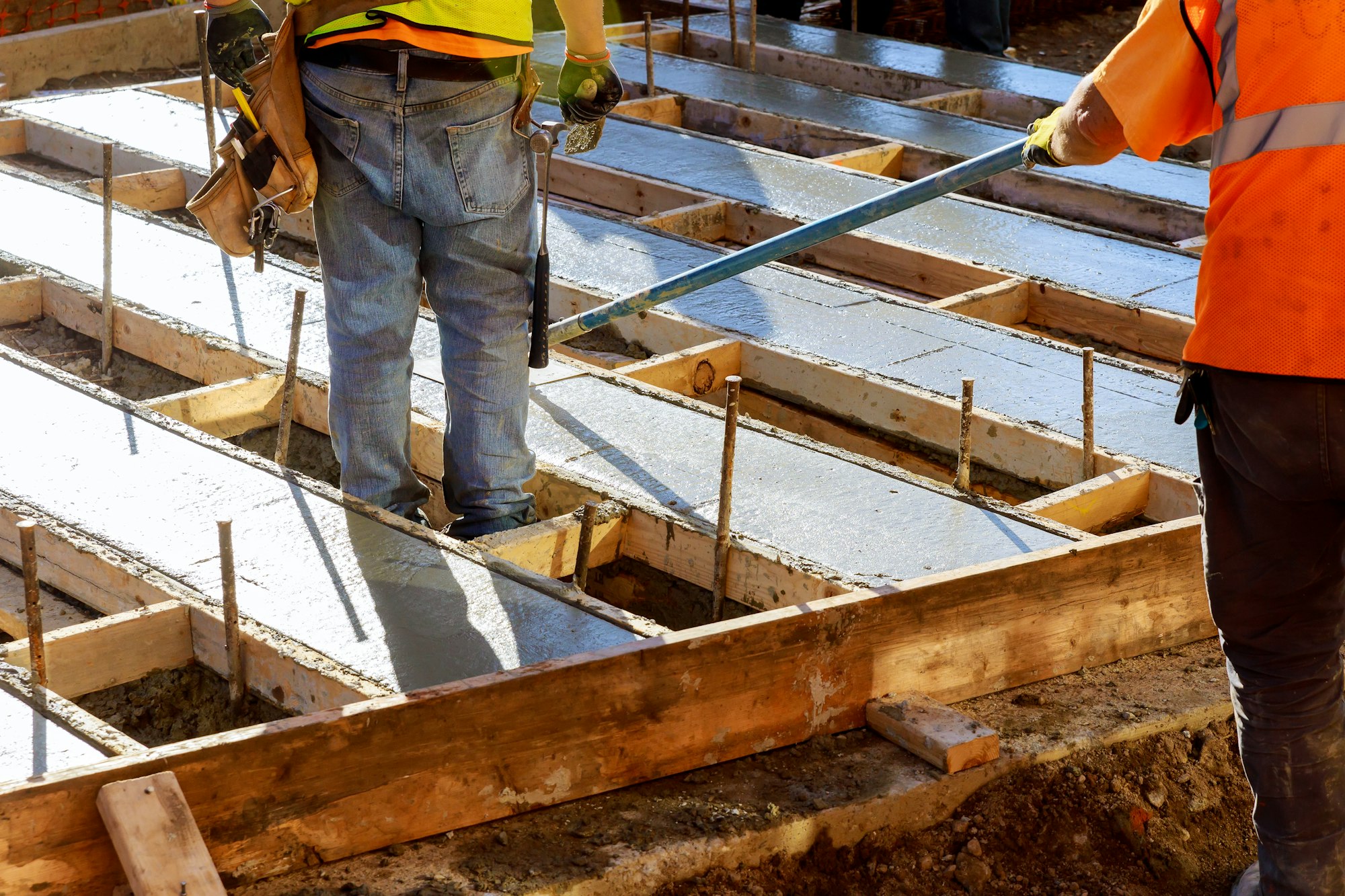 Construction workers are pouring concrete to build roads. Concrete road construction