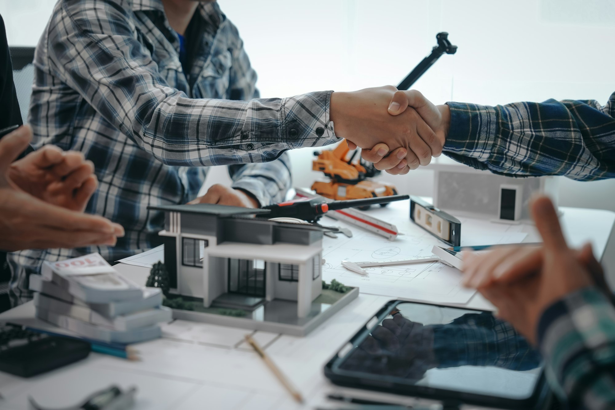 Engineers shaking hands, teamwork in meetings, drawing blueprints for condo, apartment, and house.